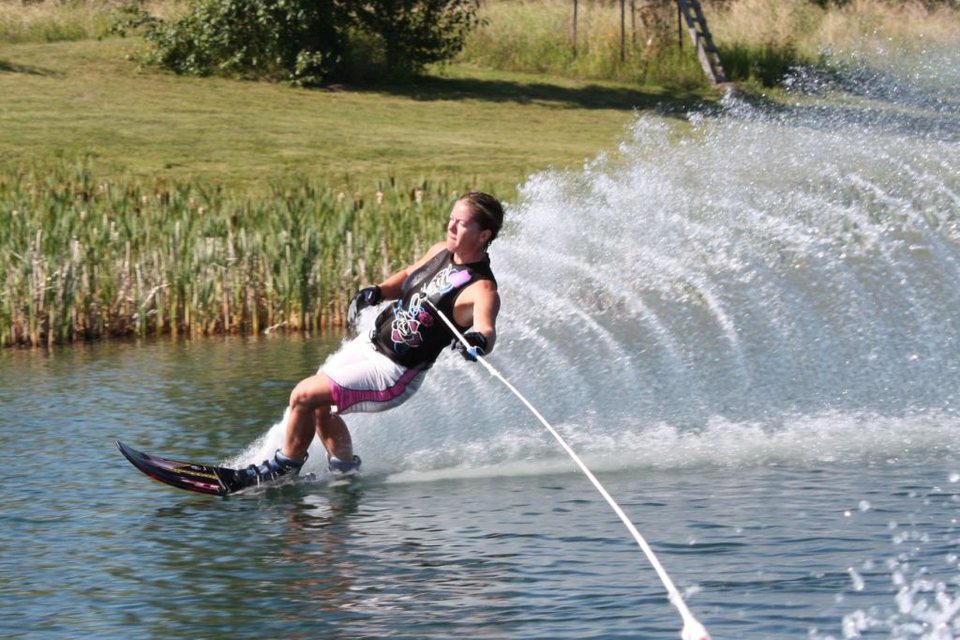 Kristy Kraus leaning into a slalom turn, shot from the boat
